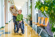 © unai - Disabled man and friend walking along in the university corridor