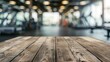 © ffunn - Blurred wooden table view of a modern gym or fitness center in the background. There is a clear focus on the wooden table or counter in the foreground. The wood surface looks rustic