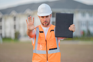 Wall Mural - Builder with stop gesture, no hand, dangerous on building concept. Portrait of builder man. Construction worker with hardhat helmet on construction site.