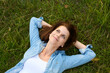 © Westend61 - Thoughtful woman with hands behind head lying on grass