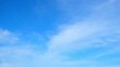 © Punyawee - A clear blue sky with a few wispy clouds scattered across it. The bright blue hue of the sky and the soft white clouds create a calm and serene atmosphere. Blue sky background.