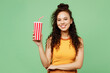 © ViDi Studio - Young woman of African American ethnicity wear yellow tank shirt top hold in hand cup of soda pop cola fizzy water isolated on plain pastel light green background studio portrait. Lifestyle concept.