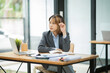 © Thitisak - Asian business woman working on computer looking at documents at office