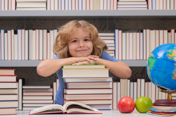 Fototapete - School boy with stack of books in library. Smart caucasian school boy kid pupil student going back to school. Education kids.