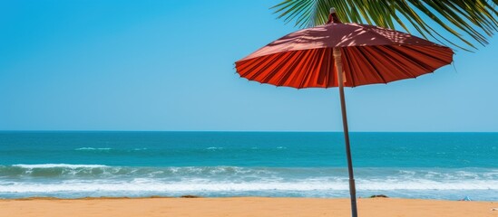 Sticker - A close up shot of a straw parasol with a national flag on an Indian Ocean beach in Hikkaduwa Sri Lanka against a backdrop of blue skies and green palm trees providing an ideal copy space image