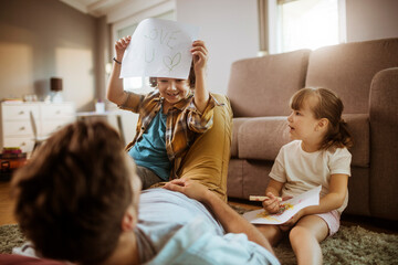 Wall Mural - Child showing 'I love you' sign to father while sibling watches