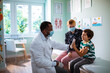 © Marko Geber - Pediatrician high fiving little boy during visit with mother at clinic