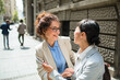 © Marko Geber - Two businesswomen laughing and talking on the street