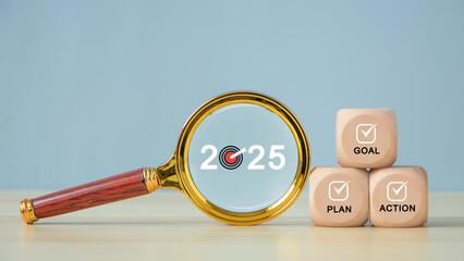 2025 new year goal plan action with target icons. Magnifying glass with text 2025 and wooden cubes with text Goal, plan. Business plan, financial plan and strategies. Development to success.