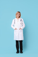 Wall Mural - Smiling doctor in uniform on light blue background