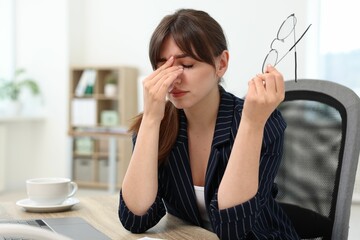 Wall Mural - Overwhelmed woman with glasses suffering at table in office