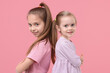 © New Africa - Portrait of cute little sisters on pink background