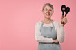 © New Africa - Happy housewife with spoons on pink background, space for text