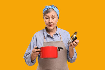 Canvas Print - Housewife with pot and lid on orange background