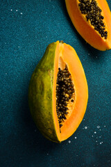 Wall Mural - Close up. Top view of fresh ripe papaya on blue concrete background.