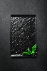 Wall Mural - Black stone square plate. On a black stone background. Mockup, free space for text.