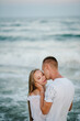 © Serhii - Closeup face. Female kissing and hugging male stand on beach ocean and enjoy sunny summer day on vacation. Woman kisses man on sand sea. Couple in love embraces on the seashore. Spend time together