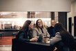 © Flamingo Images - Businesswomen laughing during a meeting in a hotel lobby during a business trip