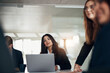 © Flamingo Images - Smiling businesswoman listening during a boardroom meeting with coworkers