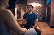 © Flamingo Images - Laughing trainer doing a health questionnaire with a woman in a gym