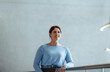 © Jacob Lund - Business woman with ginger hair stands on an interior balcony in a modern office