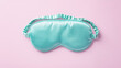 © thanksforbuying - Turquoise silk sleep mask on pastel pink background