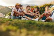 © Jacob Lund - Happy gathering of youthful individuals at a festival camp, engaging in lively conversations, sipping beer, and creating a fun atmosphere