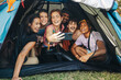 © Jacob Lund - Festival camping vibes: Friends taking a selfie together in a tent