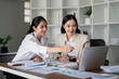 © Natee Meepian - Businesswomen working on laptop and analyzing data in office. Concept of teamwork and collaboration