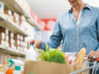© StockPhotoPro - Senior woman putting goods in the shopping cart