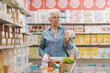 © StockPhotoPro - Senior woman reading information on a product package at the supermarket