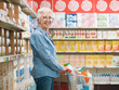 © StockPhotoPro - Confident senior woman doing grocery shopping at the supermarket