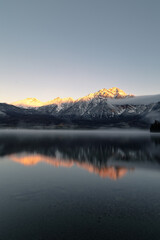 Wall Mural - Scenic view of a tranquil lake surrounded by snowy mountains