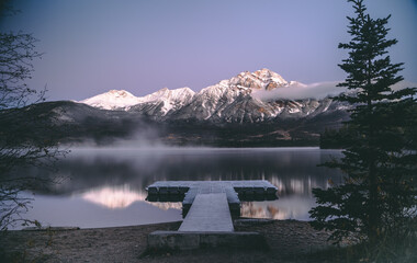 Wall Mural - Scenic view of a tranquil lake surrounded by snowy mountains