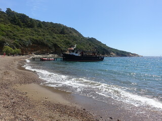 Wall Mural - Shot of a boat on the shore near mountains and a water surface