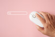 © Ratana21 - elderly hand using wireless computer mouse with search bar on sweet pink background, top view. including copy space