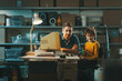© StockPhotoPro - Happy father and son posing together in the garage