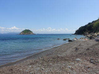 Sticker - Scenic view of a rocky beach against the sea on a sunny day