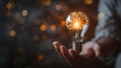 © Sami - New shiny smart idea or brainstorming concept with hand holding shining lightbulb with glowing brain inside