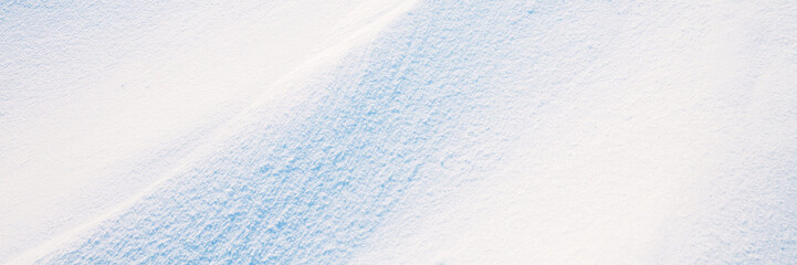 Wall Mural - beautiful winter background with snowy ground. natural snow texture. wind sculpted patterns on snow 