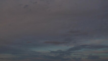 Wall Mural - The evening sky gradually darkens. White clouds at sunset move slowly across the sky as night falls. Calm, nostalgic background with a feeling of slight sadness and sadness.