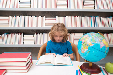 Fototapete - School and students in classroom. Education kids. Child pupil student in the school class. Studying and learning concept. School boy in the library near school supplies. Kid learn geography with globe