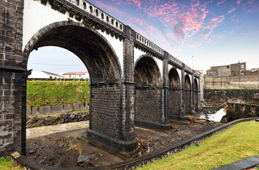 Wall Mural - Charming architecture and natural beauty of Ribeira Grande, Sao Miguel, through this picturesque view of its iconic arch bridge and serene river setting.