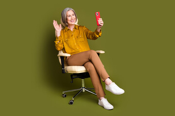 Poster - Full length photo of cheerful attractive lady dressed blouse video call modern device waving hi empty space isolated khaki color background