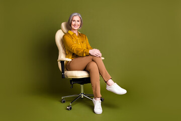 Canvas Print - Full length photo of cheerful attractive lady dressed blouse sitting office chair empty space isolated khaki color background