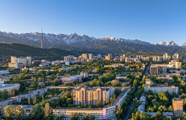 Wall Mural - View from a quadcopter of the central part of the Kazakh city of Almaty on a spring morning against the backdrop of a mountain range