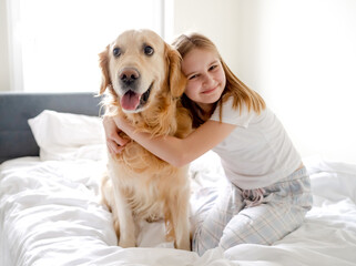 Sticker - Girl Poses With Golden Retriever In Bed In The Morning In A Bright Room