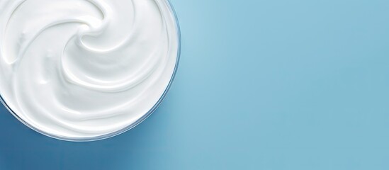 Wall Mural - A delicious organic yogurt is displayed on a light blue surface with a top down perspective providing room for text in the image. with copy space image. Place for adding text or design