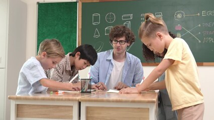 Wall Mural - Smart teacher explain idea while diverse children drawing mind map while group of diverse student working together to do class work. Attractive instructor teaching and talking about working. Pedagogy.