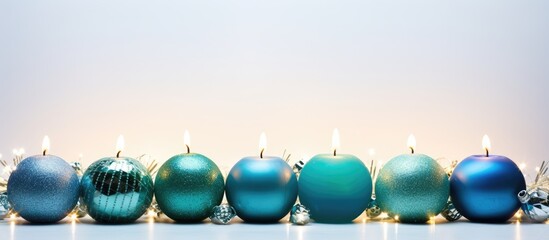 Wall Mural - a festive copy space image featuring christmas candles in green and blue hues against a white backdr